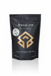 Waxx Inn Elixir Expert Stripless Hot Wax Beads 1kg – black pouch with golden Elixir label and warm gold wax beads, stripless hard wax for all hair types, professional formula made in Italy