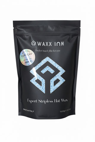 Waxx Inn Curaçao Expert Stripless Hot Wax Beads 1kg black pouch with light blue beads spilled – rosin-free hard wax for coarse hair, professional formula made in Italy