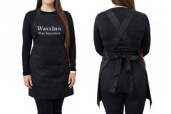 Black apron with 'WaxxInn Wax Specialist' text on a white background